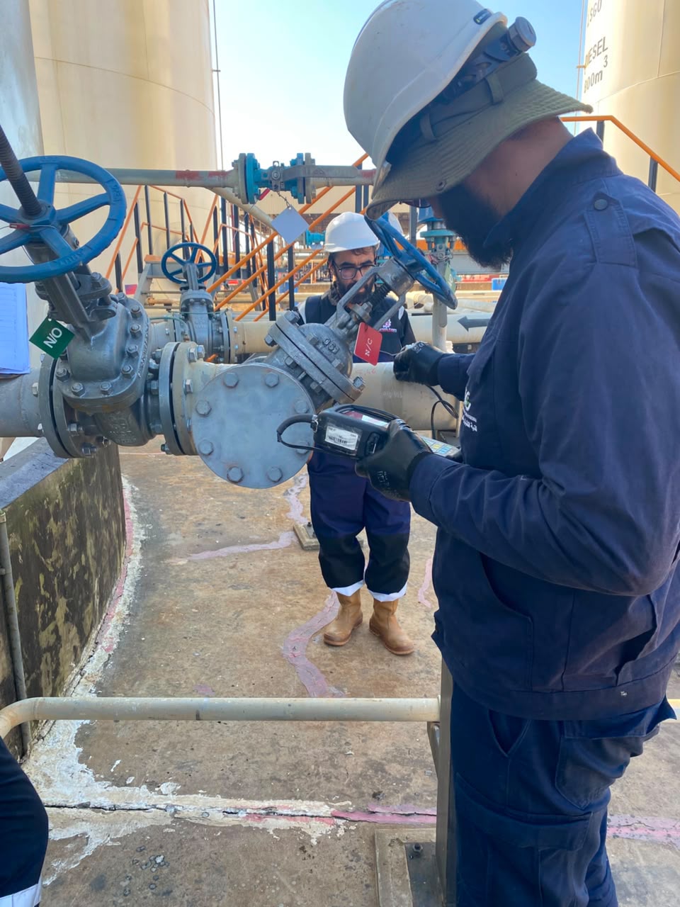 Technician taking a measurement on industrial piping