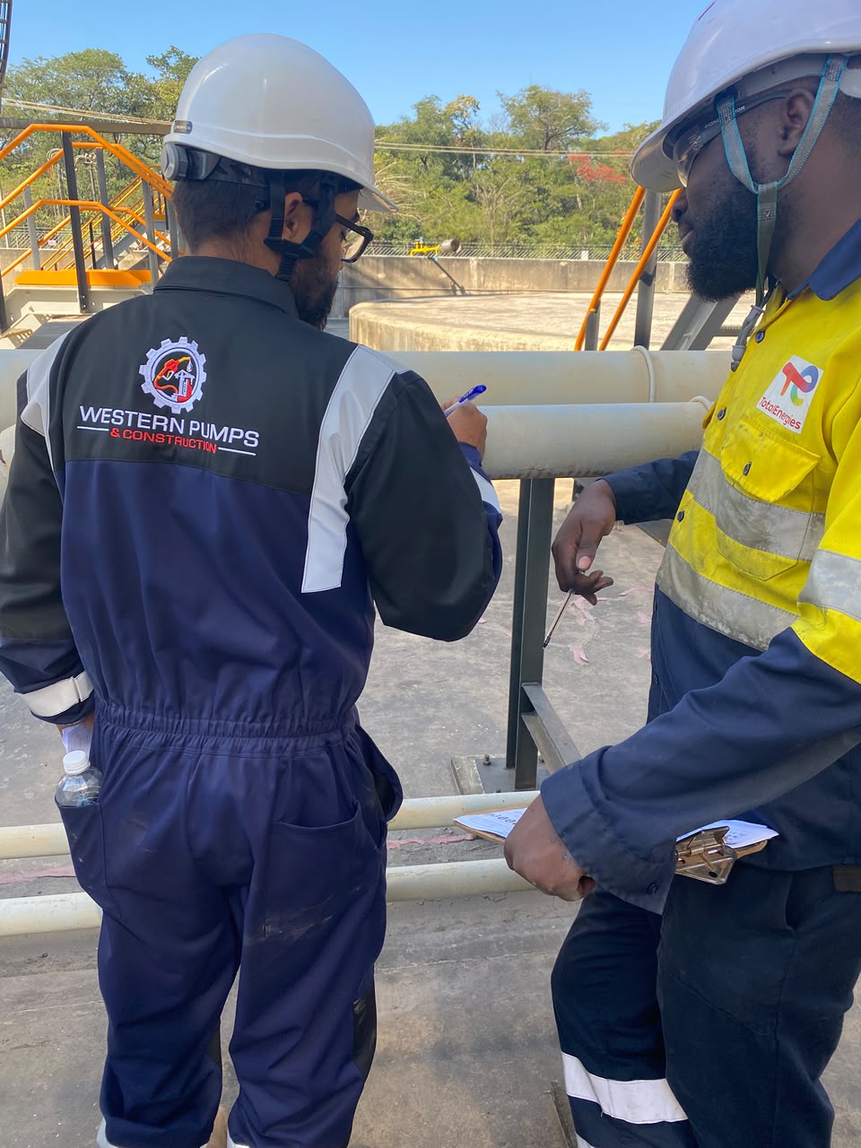 Western Pumps team documenting an inspection beside industrial piping