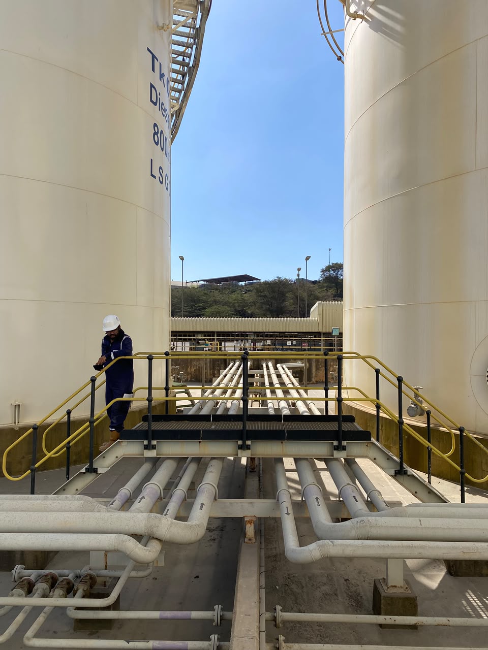 Inspector assessing storage tanks and associated pipework